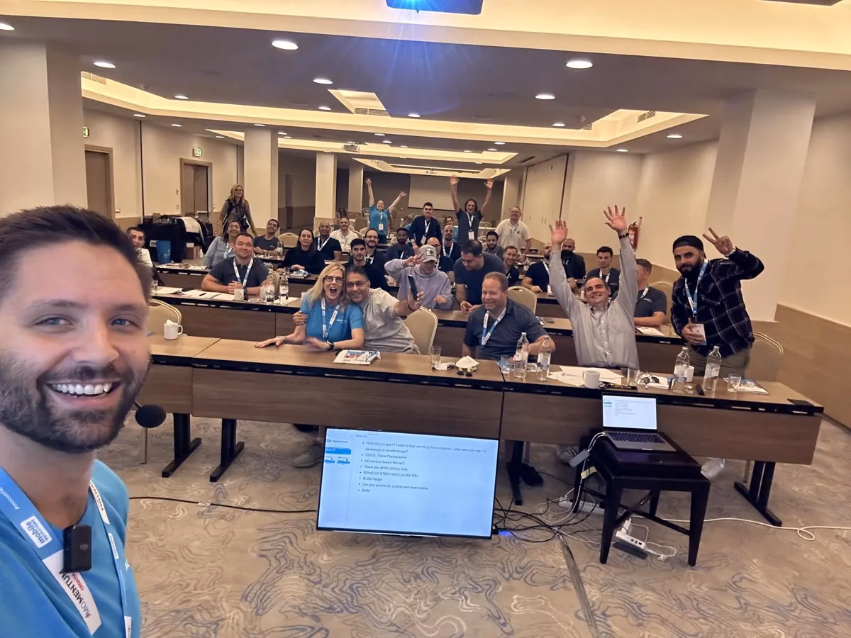 Griff taking a selfie in front of a workshop room of founders cheering